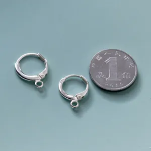Κοντινό πλάνο κουμπωμάτων σκουλαρικιών S925 με νόμισμα για σύγκριση μεγέθους προϊόντος