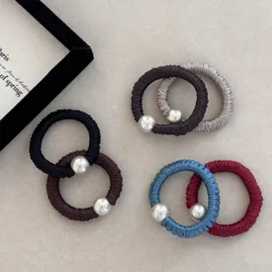Detailed view of various colorful silk elastic scrunchies with silver pearl beads