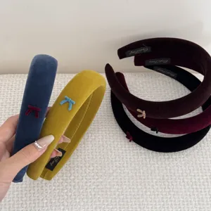 Close-up of stylish velvet sponge headbands with cute bow details in multiple colors