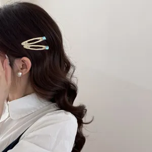 Dettaglio di fermagli per capelli a scacchi con strass blu sui capelli ondulati
