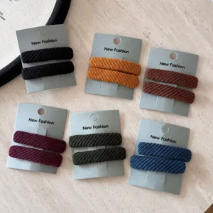 Dettaglio ravvicinato di fermagli BB rettangolari in tessuto twill in vari colori vivaci