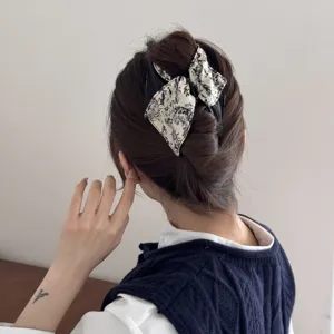 Rear view of model wearing a French vintage ink print banana clip with hair bow