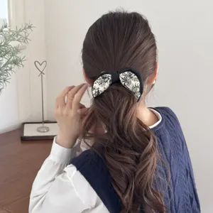 Elegant French vintage floral print banana clip hair accessory on wavy brown ponytail