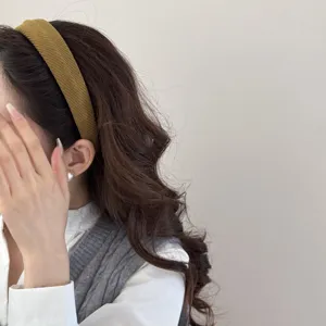 Detailed macro view of mustard yellow textured sponge headband worn by an Asian model