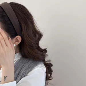Detailed view of a brown textured sponge headband styled on a model with wavy hair