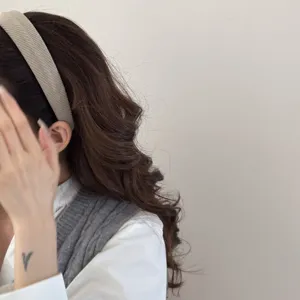 Side view of a textured beige sponge headband worn by a model for a volumizing look.