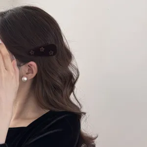 Gros plan détaillé d'un mannequin portant une pince à cheveux en velours marron et étoiles.