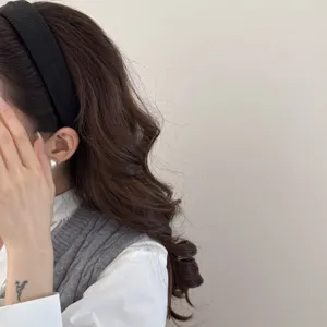 Detailed side view of a stylish woman wearing a classic black padded sponge headband