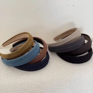 Detail of corduroy padded headbands in various autumn colors on a white surface