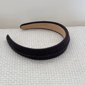 Detailed view of black padded headband featuring a thick ribbed texture