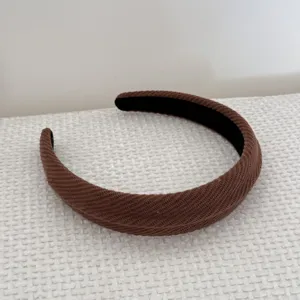 Close-up detail of brown ribbed texture on a padded high top sponge headband