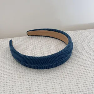 Detail shot of blue corduroy sponge padded headband with soft brown inner lining.