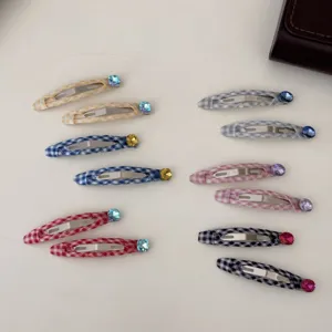 Set di 12 fermagli per capelli BB a scacchi con strass colorati su fondo bianco.