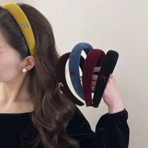 Close-up of elegant velvet padded headbands with dainty bow accents in various colors