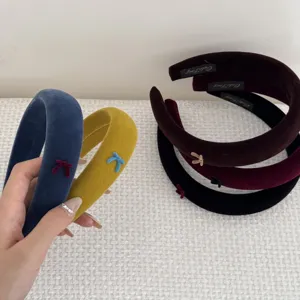 Close-up detail of soft velvet padded headbands featuring delicate bow accents in various colors