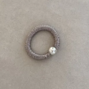 Close-up of elegant taupe silk hair ring with metallic silver ball bead detail