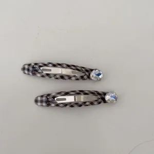 Primo piano di fermagli per capelli a quadretti con grandi e brillanti strass trasparenti