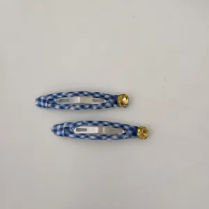 Dettaglio ravvicinato di fermagli per capelli a quadretti blu e bianchi con strass