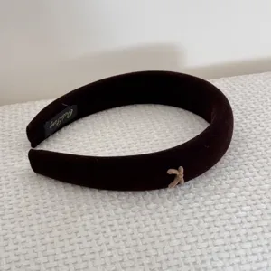 Detailed macro of dark velvet sponge headband with a small beige bow.