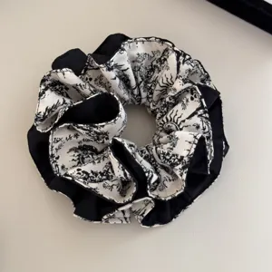 Close-up of French vintage toile de jouy print hair scrunchie in black and white