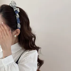 Close-up of a blue and white floral fabric headband worn with a white blouse