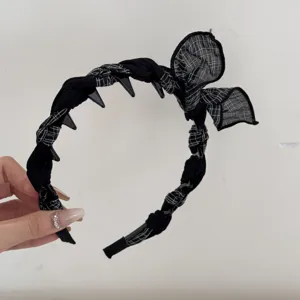 Detailed view of black plaid rabbit ear headband with non-slip inner teeth