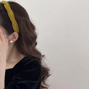 Side view of a vintage mustard yellow velvet twisted headband on a model.