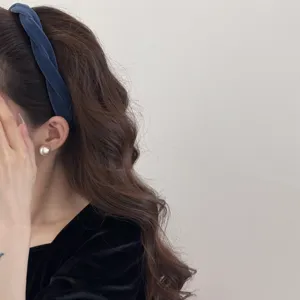 Side view of a blue velvet twisted headband on a model with long wavy hair