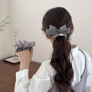 Detail view of cotton filled bow scrunchie set worn in a low ponytail