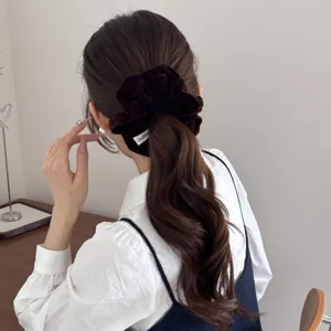 Detailed view of a vintage dark brown velvet scrunchie worn on a stylish low ponytail