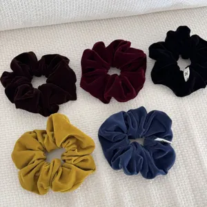 Detailed macro shot of five velvet scrunchies in vintage colors for elegant hairstyles