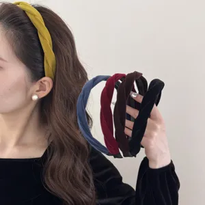 Model wearing and holding several elegant twisted velvet headbands in various colors