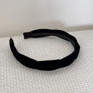 Detailed view of the elegant black twisted velvet headband with a soft texture