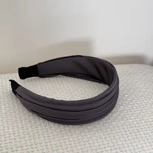 Vue détaillée du serre-tête élégant en tissu plissé gris anthracite sur fond blanc.