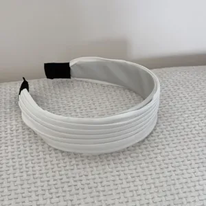 Vue détaillée d'un serre-tête large plissé blanc au style français minimaliste.