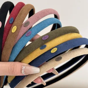 Close-up of minimalist narrow suede headbands in various colors with Love labels