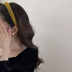 Gros plan d'un serre-tête floqué jaune moutarde avec un cœur bleu sur un mannequin