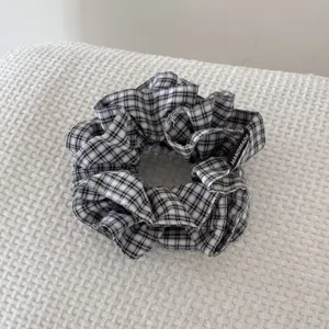 Vue détaillée d'un chouchou à carreaux noir et blanc avec étiquette fait main