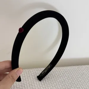 Détail d'un serre-tête floqué noir avec un petit accent de cœur bordeaux