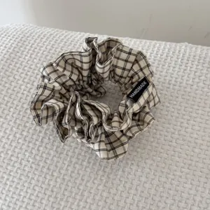 Gros plan d'un chouchou en tissu écossais rétro avec une étiquette faite à la main