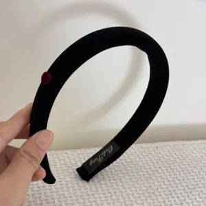 Détail d'un serre-tête en éponge floquée noire avec un petit accent de cœur rouge