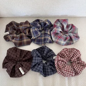 Close-up of six assorted checkered fabric hair scrunchies in vintage dark colors.