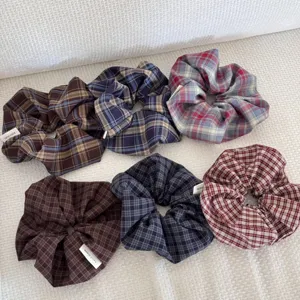Detailed view of six Korean style vintage dark plaid fabric scrunchies on white background