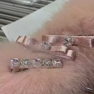 Detail shot of pink satin duckbill hair clips decorated with square rhinestones