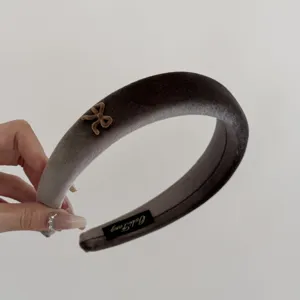 Detail view of a luxury grey velvet wide headband with a small bow accent