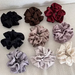 Gros plan de chouchous en satin plissés à double couche en plusieurs couleurs.