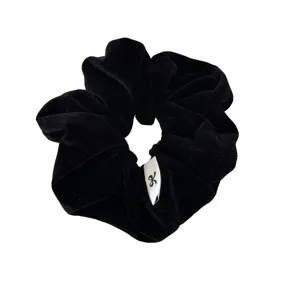 Retro black velvet scrunchie with bow logo tag for elegant hair styling and buns