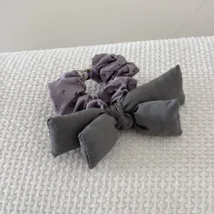 Close-up of a vintage purple floral scrunchie with a large charcoal gray fabric bow
