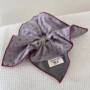 Detail showing the floral pattern and 'Dynamic Life' label on oversized scrunchie