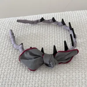 Vintage gray fabric-wrapped headband with bow and plastic teeth detail hair accessory